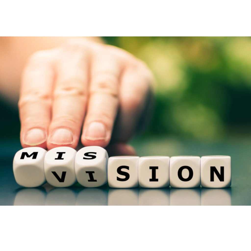 Sieben Wuerfel mit Buchstaben bilden die Worter Vision und Mission und eine Hand dreht die ersten beiden Wuerfel um, sodass die drei Anfangsbuchstaben von Mission und Vision zulesen sind