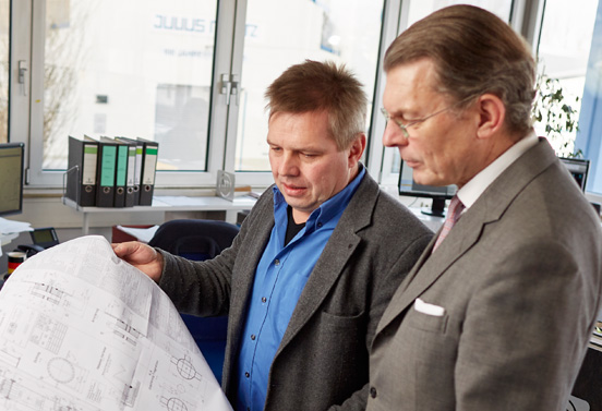 Vorteile Interim Management Fotografie von einem Kunden und einem Interim Manager die gemeinsam auf einen Bauplan schauen