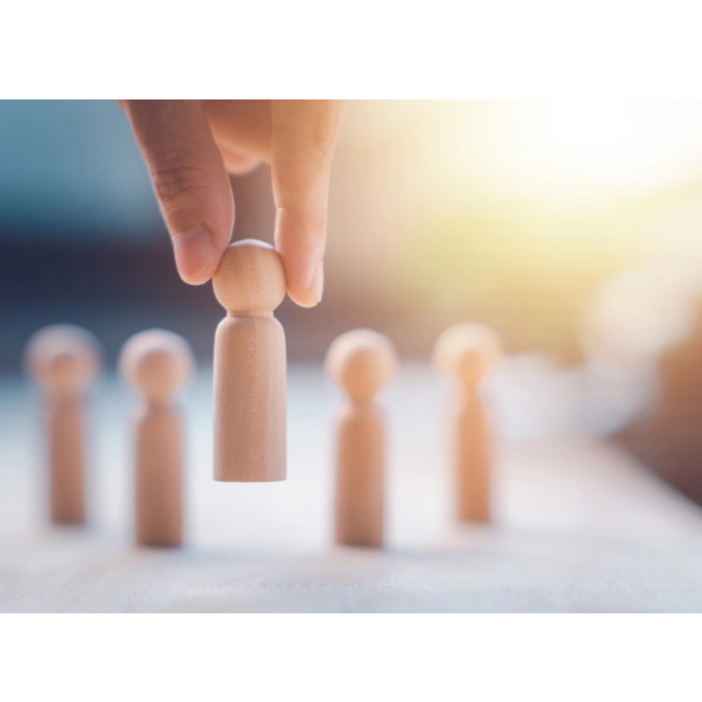 Change Management - Interim Profis Mehrere Spielfiguren befinden sich auf einer Fläche und ein Spielfigur wird mit einer Hand angehoben
