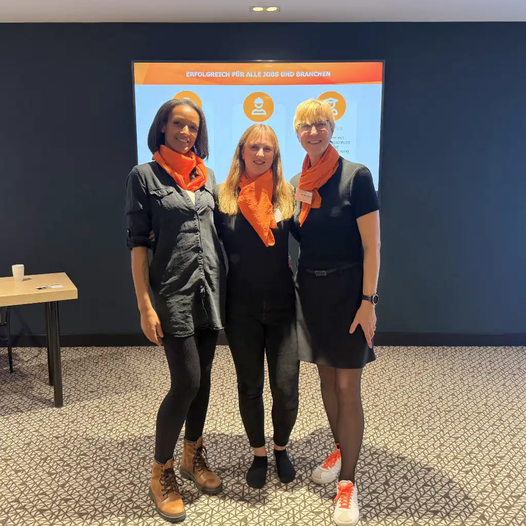 Josephine Elzain, Marie-Celine Baum und Annette Elias stehen gemeinsam vor einer Leinwand